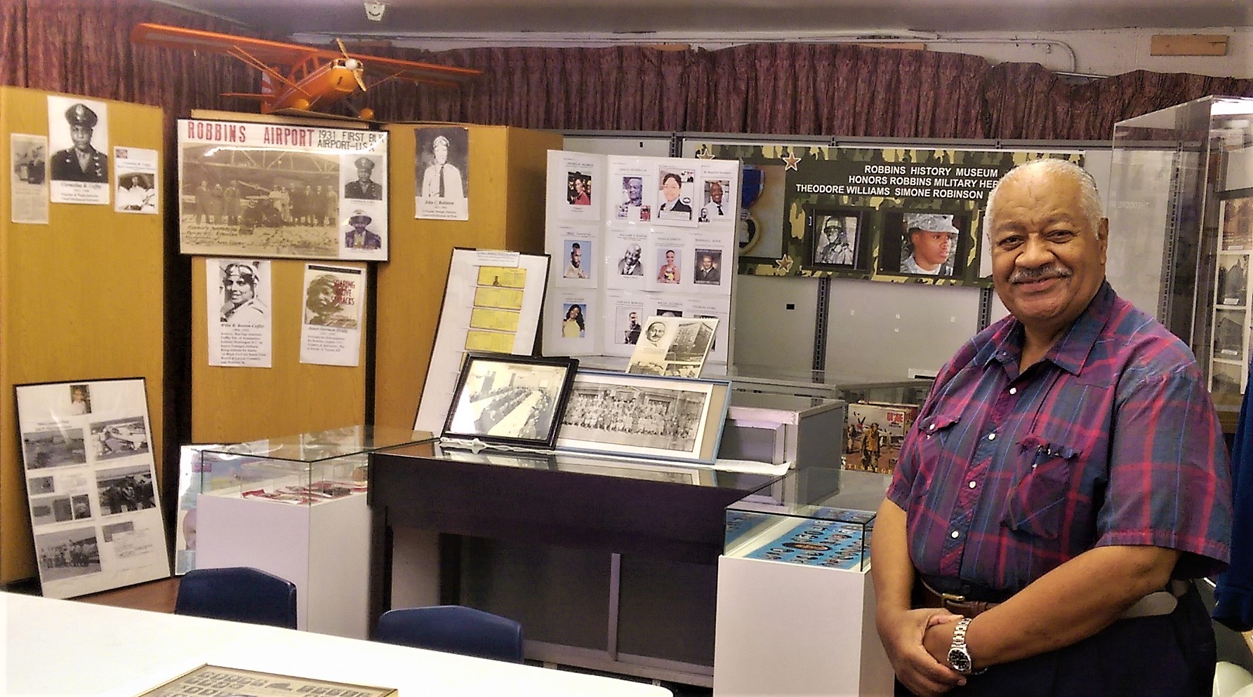black man in front of exhibits about robbins history